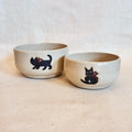 Pair of little cream stacking snack bowls with matte black cat decoration