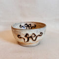 Footed cream-glazed coupe bowl with brown ribbon decoration